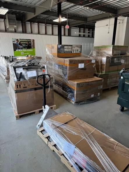 Shrink-wrapped liquidation pallets and a pallet jack on the SlickBuy warehouse floor