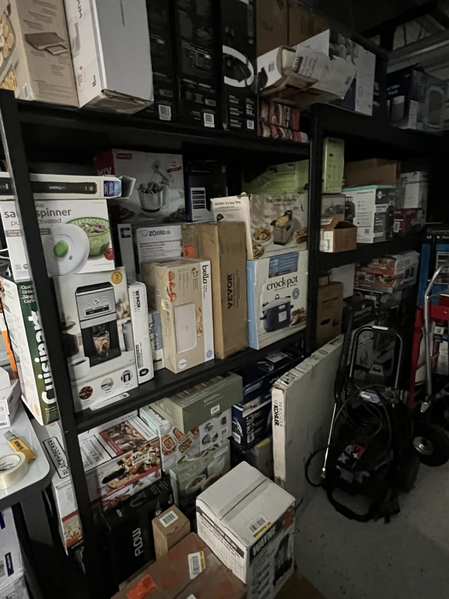 Warehouse shelves stacked with boxed appliances and household goods sorted for auction