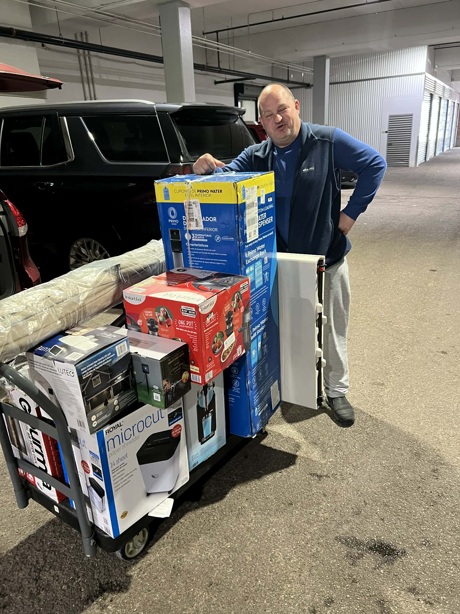 A happy buyer with a cart full of winning lots at local pickup
